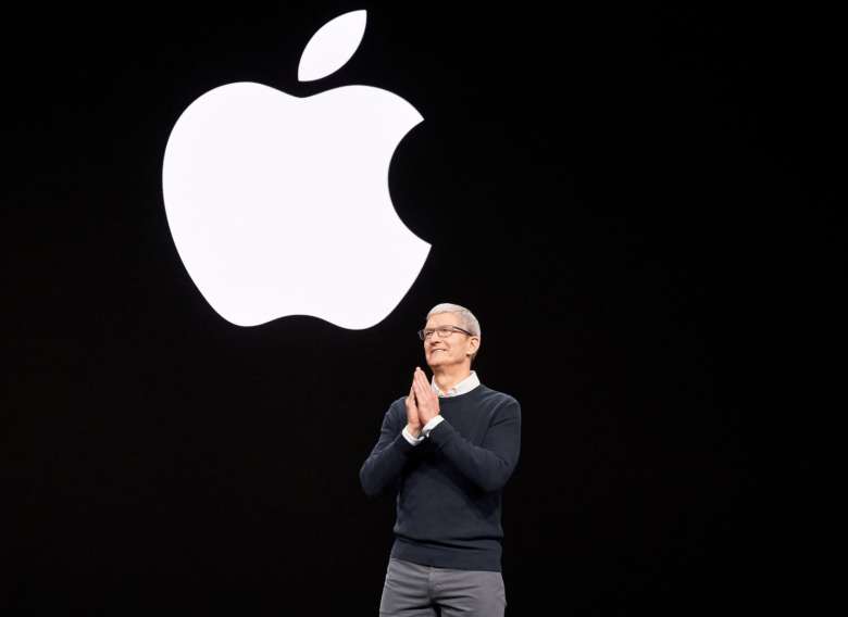 Tim Cook con il logo Apple alle spalle